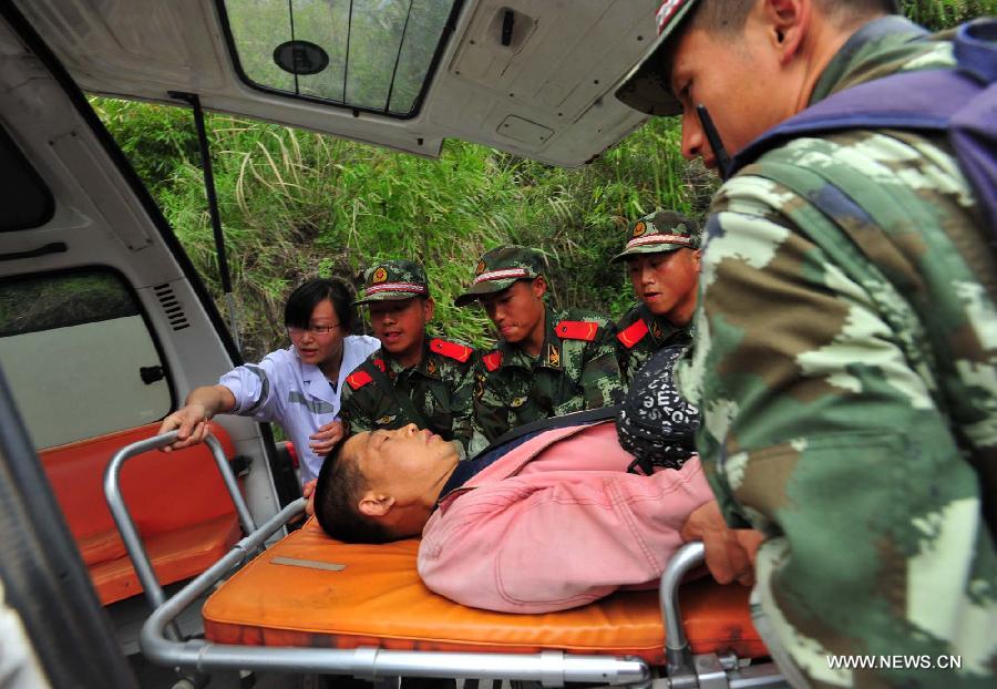 An injured man is carried to an ambulance in Baosheng Township, Lushan County, southwest China's Sichuan Province, April 21, 2013. Baosheng Township is another seriously affected area in Lushan. Search and rescue work continued here Sunday, and the work for restoring roads and communications are conducted in the pipelines. (Xinhua/Xiao Yijiu)