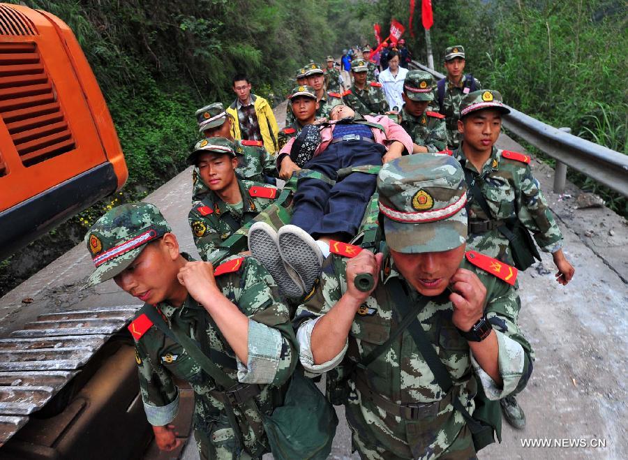 Soldiers carry an injured villager in Baosheng Township, Lushan County, southwest China's Sichuan Province, April 21, 2013. Baosheng Township is another seriously affected area in Lushan. Search and rescue work continued here Sunday, and the work for restoring roads and communications are conducted in the pipelines. (Xinhua/Xiao Yijiu)