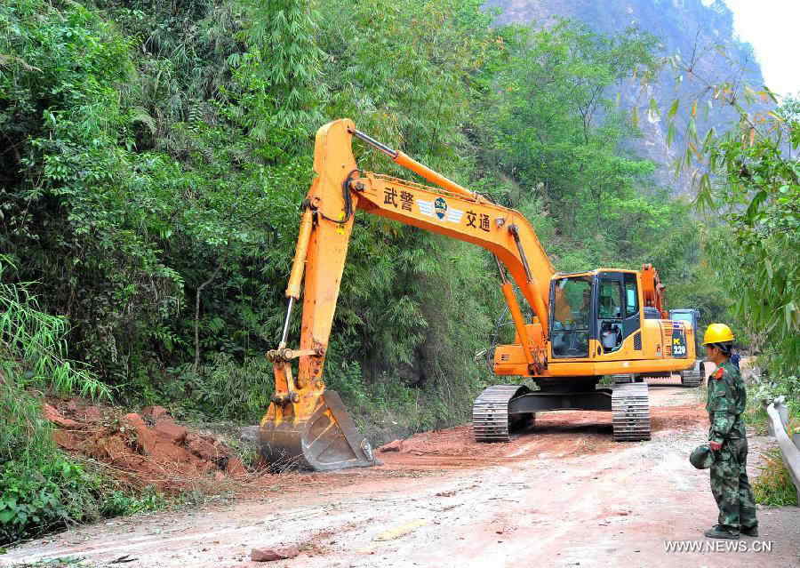 An excvavtor works to clear a road linking to Baosheng Township, Lushan County, southwest China's Sichuan Province, April 21, 2013. Baosheng Township is another seriously affected area in Lushan. Search and rescue work continued here Sunday, and the work for restoring roads and communications are conducted in the pipelines. (Xinhua/Xiao Yijiu)