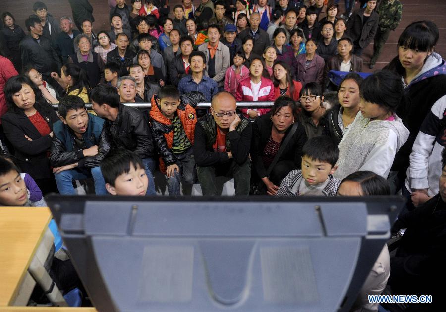 Displaced people watch TV reporting the news on the earthquake in a public shelter in the quake-hit Baoxing County, southwest China's Sichuan Province, April 21, 2013. By far, a total of 28,000 people in the county have been evacuated to safety places. A 7.0-magnitude earthquake hit Sichuan at 8:02 a.m. Saturday Beijing time. (Xinhua/Luo Xiaoguang) 
