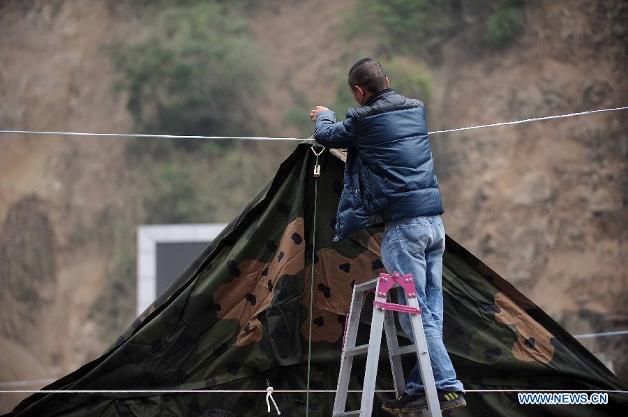 Local resident sets up a tent in the quake-hit Baoxing County, southwest China's Sichuan Province, April 21, 2013. By far, a total of 28,000 people in the county have been evacuated to safety places. A 7.0-magnitude earthquake hit Sichuan at 8:02 a.m. Saturday Beijing time. (Xinhua/Xue Yubin) 