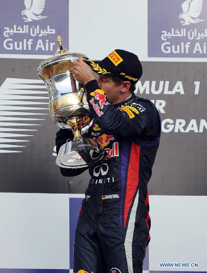 Red Bull driver Sebastian Vettel kisses the winner's trophy during the victory ceremony of the Bahrain F1 Grand Prix at the Bahrain International Circuit in Manama, Bahrain, on April 21, 2013. (Xinhua/Chen Shaojin)