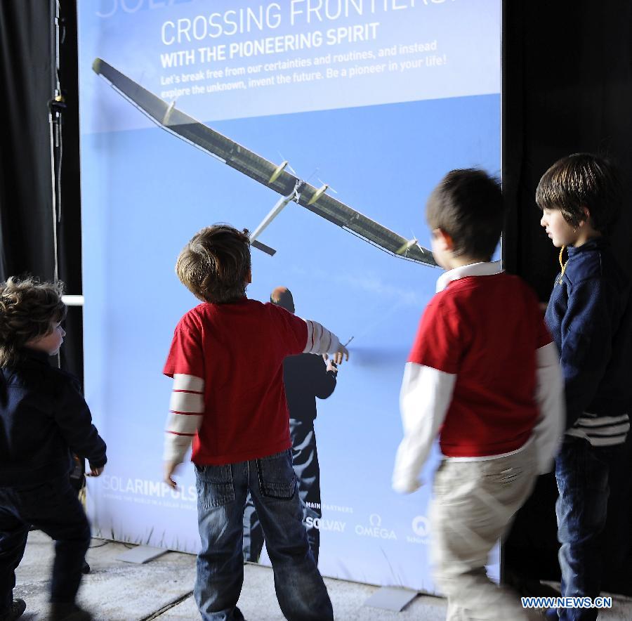 Kids view an introductory poster for "Solar Impulse" at the Moffett Federal Airfield, Mountain View, California, April 20, 2013. The Swiss-made world's biggest solar-powered aircraft that doesn't use a single drop of fuel will begin traveling across the United States in early May. It'll take off on May 1 from the San Francisco Bay area and reach New York's JFK airport, the final destination, in early July. (Xinhua/Chen Gang) 
