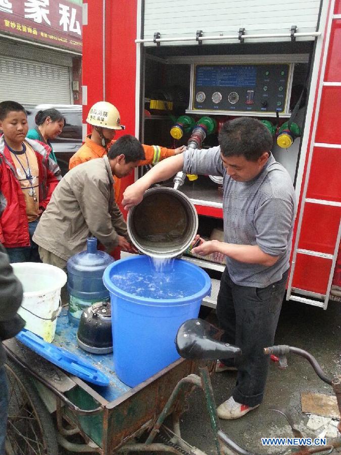 People fetch water for daily needs from a fire engine in quake-hit Lushan County of Ya'an City, southwest China's Sichuan Province, April 21, 2013. A 7.0-magnitude quake jolted Lushan County of Ya'an on Saturday morning. (Xinhua)