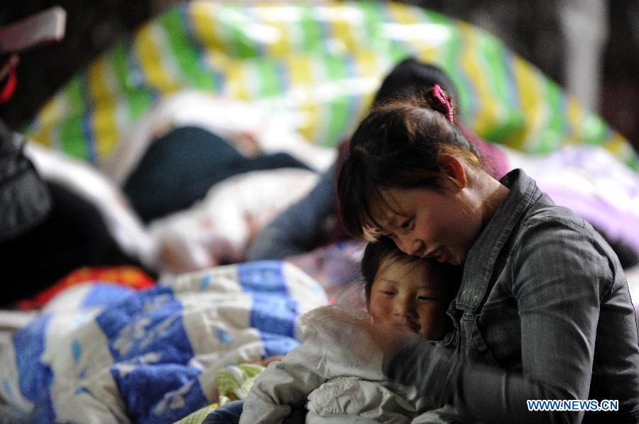 A mother tells stories to her child in a temporary tent after the deadly earthquake in Ya'an City, southwest China's Sichuan Province, April 21, 2013. A 7.0-magnitude earthquake jolted Lushan County of Ya'an City on April 20 morning. (Xinhua/Wen Tao) 