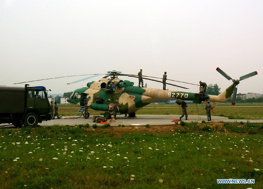 Crew members check a helicopter which returned after conveying disaster-relief materials to quake-hit areas in southwest China's Sichuan Province, April 21, 2013. A 7.0-magnitude earthquake jolted Lushan County of Ya'an City on April 20 morning. (Xinhua/Li Gang)