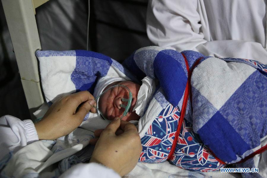 A newborn baby girl is given oxygen in a tent functioned as an operating room of the People's Hospital in Baoxing County, Ya'an City, southwest China's Sichuan Province, April 21, 2013. The girl was the first baby born in the hospital after the earthquake. A 7.0-magnitude earthquake jolted Lushan County of Ya'an City on Saturday morning. (Xinhua/Zhang Yuanpei) 