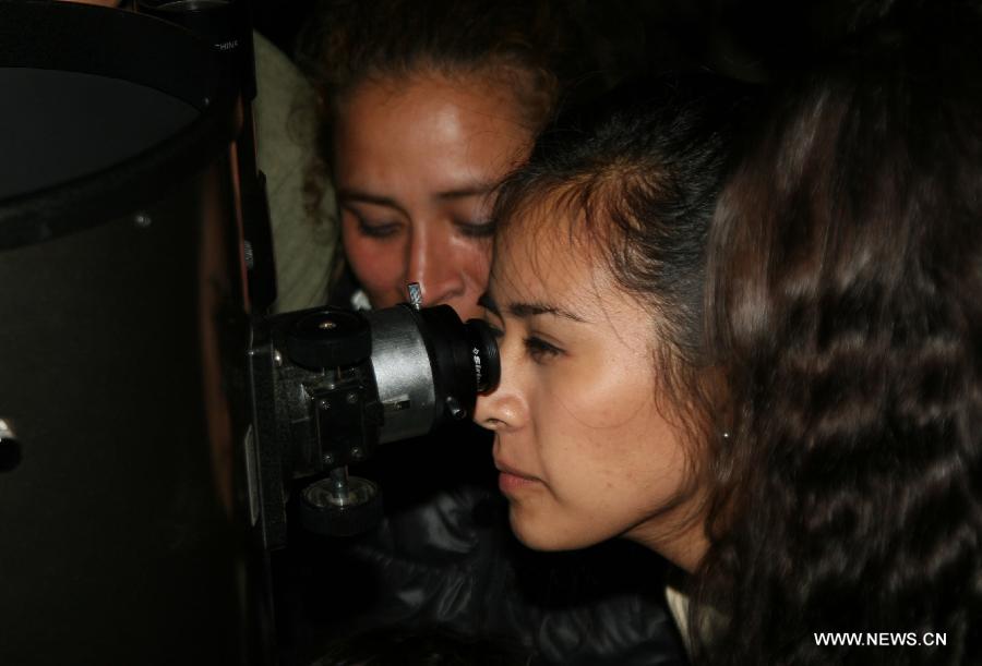 A woman looks through a telescope at the Campo Marte Park in Lima, Peru, April 20, 2013. The Jesus Maria governor organized the exhibition "Party of Astronomy" to celebrate the coming Astronomy Day. (Xinhua/Luis Camacho)