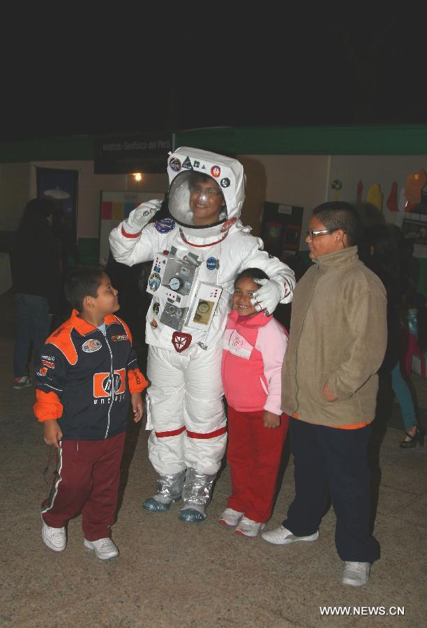 A group of children pose for a photograph with a man dressed as an astronaut at the Campo Marte Park in Lima, Peru, April 20, 2013. The Jesus Maria governor organized the exhibition "Party of Astronomy" to celebrate the coming Astronomy Day. (Xinhua/Luis Camacho) 