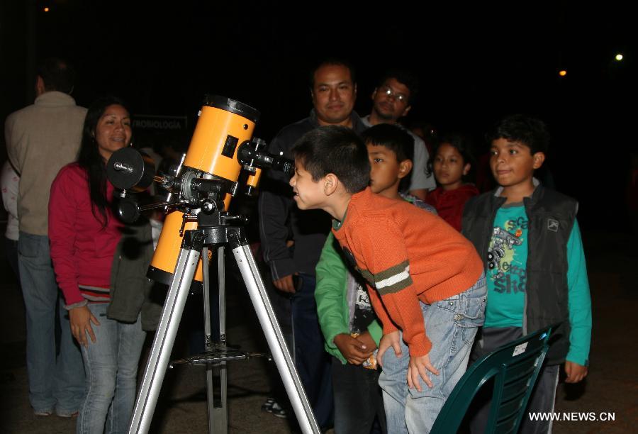 A boy looks through a telescope at the Campo Marte Park in Lima, Peru, April 20, 2013. The Jesus Maria governor organized the exhibition "Party of Astronomy" to celebrate the coming Astronomy Day. (Xinhua/Luis Camacho)