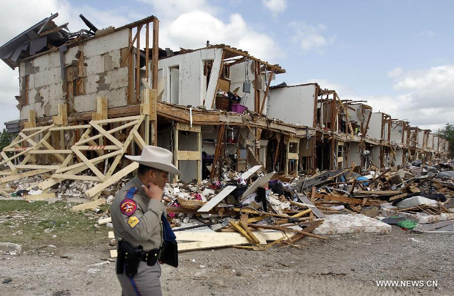 A policeman stands guard on the blast site in West, Texas, the United States, on April 21, 2013. The seat, or center of an explosion that blew off a fertilizer plant and almost razed the U.S. town of West had been located, a U.S. Official said Sunday. Assistant Texas fire marshal Kelly Kistner told a press conference here that the locationing of the center of the explosion is important to the investigation of the blast. But he said the cause of the fire and blast remained unknown. The explosion left a large crater in the middle of the plant, said Kistner, but declined to elaborate on the dimension of the crater or give other details. (Xinhua/Michael Ainsworth)