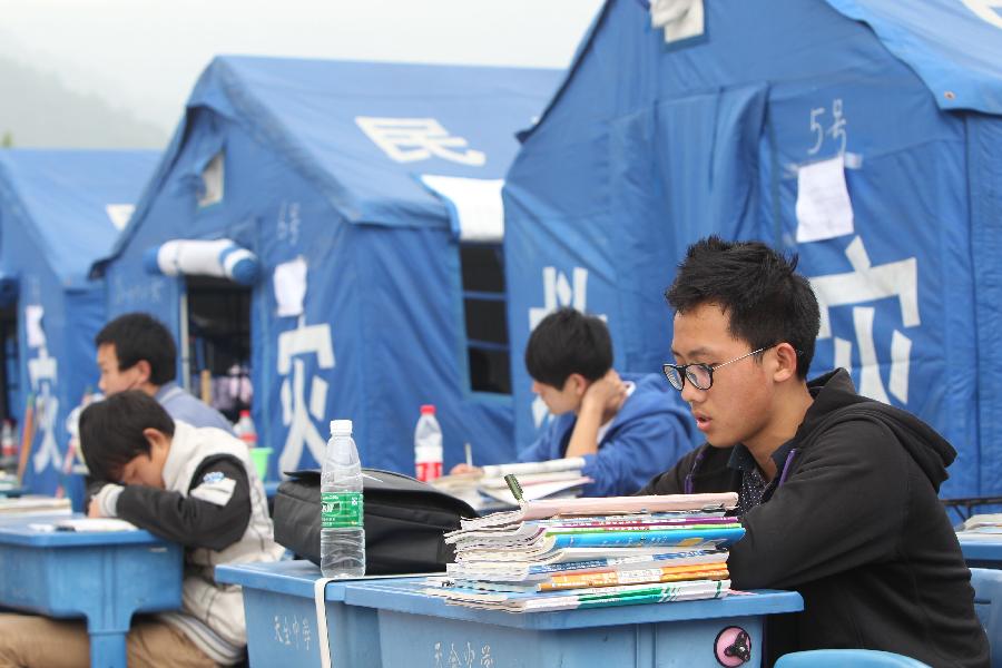 Li Yawen (1st R), a high school student, studies to prepare the college entrance exam this summer outside tents at a temporary settlement at the Tianquan Middle School in quake-hit Tianquan County, Ya'an City, southwest China's Sichuan Province, April 22, 2013. A 7.0-magnitude earthquake jolted Lushan County of Ya'an City in the morning on April 20. (Xinhua/Xing Guangli)