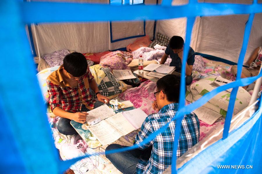 High school students study to prepare the college entrance exam this summer in a tent at a temporary settlement at the Tianquan Middle School in quake-hit Tianquan County, Ya'an City, southwest China's Sichuan Province, April 22, 2013. A 7.0-magnitude earthquake jolted Lushan County of Ya'an City in the morning on April 20. (Xinhua/Liu Jinhai)