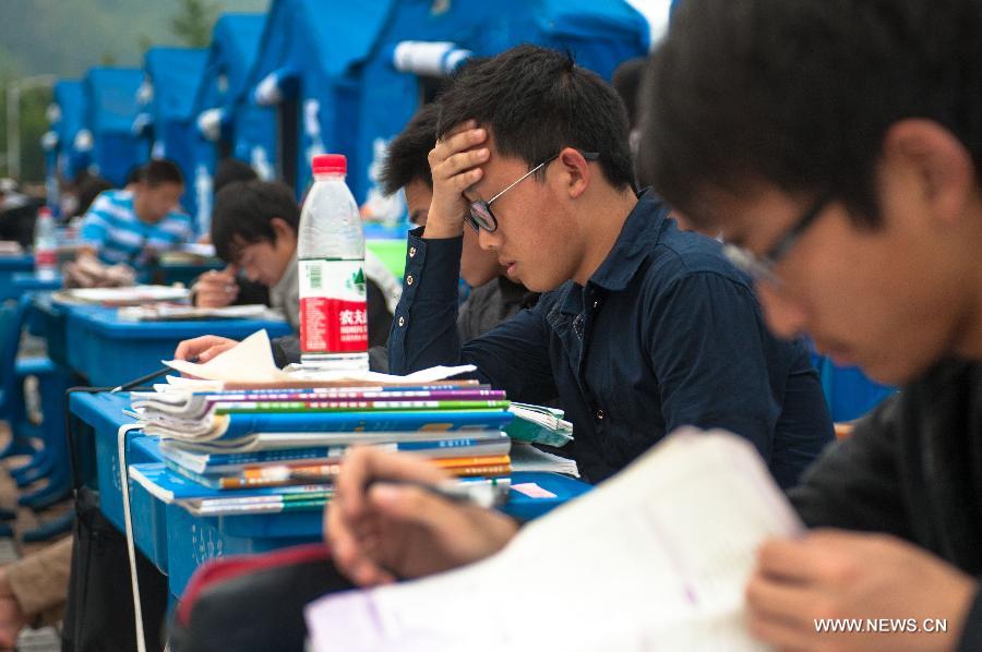 High school students study to prepare the college entrance exam this summer outside tents at a temporary settlement at the Tianquan Middle School in quake-hit Tianquan County, Ya'an City, southwest China's Sichuan Province, April 22, 2013. A 7.0-magnitude earthquake jolted Lushan County of Ya'an City in the morning on April 20. (Xinhua/Liu Jinhai)