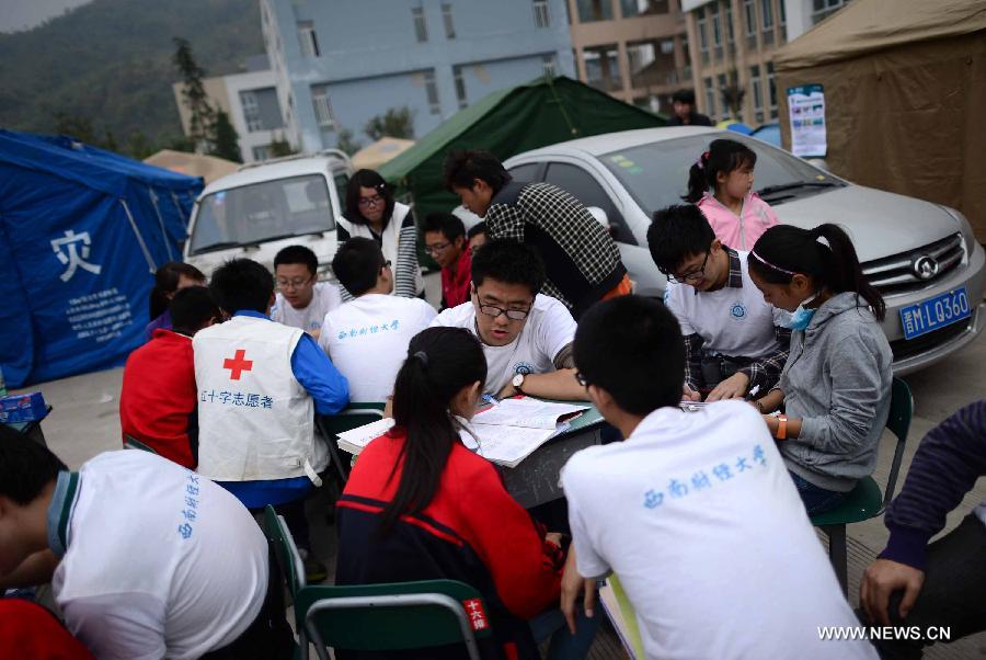 Volunteers from Southwestern University of Finance and Economics tutor students at a temporary school at the Lushan Middle School in Lushan County, southwest China's Sichuan Province, April 22, 2013. A temporary school was set up here Monday by 17 volunteers from Southwestern University of Finance and Economics. A 7.0-magnitude earthquake jolted Lushan County of Ya'an City in the morning on April 20. (Xinhua/Jiang Hongjing) 
