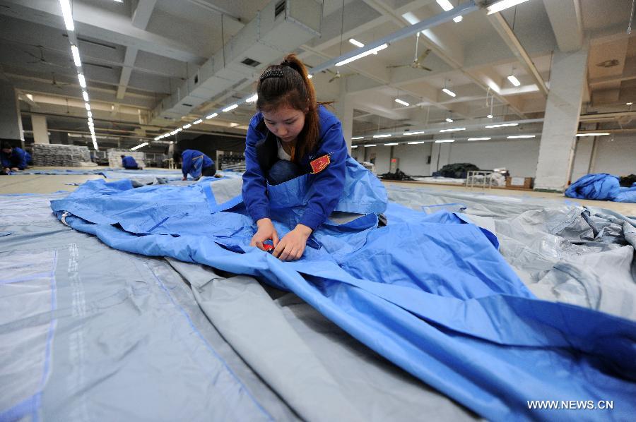 A worker makes tents for disaster relief at a company in Deqing County in east China's Zhejiang Province, April 22, 2013. The first 500 tents made by the company are to be sent to southwest China's Sichuan Province, where a 7.0-magnitude earthquake jolted Lushan County of Ya'an City in the morning on April 20. (Xinhua/Ju Huanzong)  
