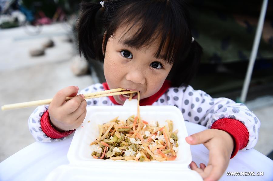 Four-year-old girl Du Xinrui has lunch at a temporary settlement site in the quake-hit Lushan County, southwest China's Sichuan Province, April 22, 2013. (Xinhua/Zhang Hongxiang) 