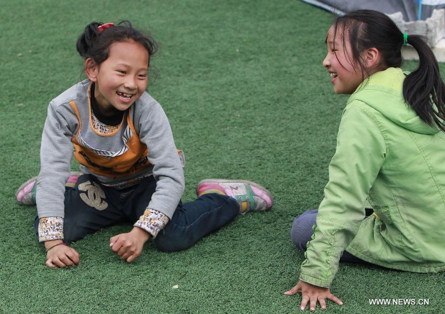 Girls play outside a tent at a temporary settlement in the quake-hit Baoxing County, southwest China's Sichuan Province, April 22, 2013. (Xinhua/Pei Xin)