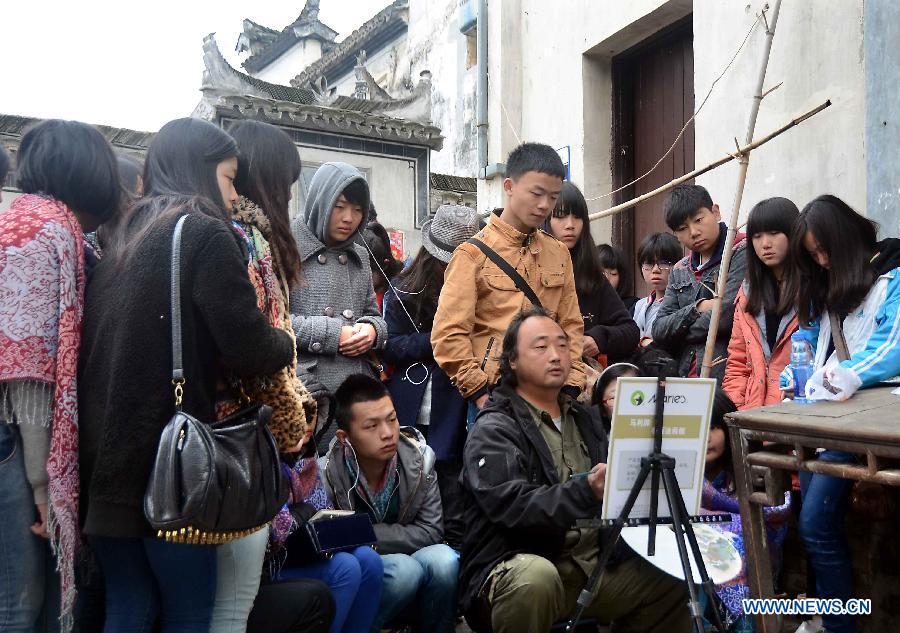 A teacher teaches drawing to students in Hongcun Village, a famous tourist site in east China's Anhui Province, April 22, 2013. Hongcun, one of the UNESCO World Heritage Sites, took on beautiful spring view and attracted lots of art students. (Xinhua/Wang Song)