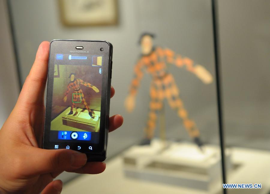 A visitor takes photo of an artwork in an exhibition of "From Picasso to Barcelo - Spanish Sculpture of the 20th Century" in Beijing, capital of China, April 22, 2013. A total of 79 pieces of artworks of famous Spanish artists were presented in the exhibition which celebrated the 40th anniversary of the establishment of diplomatic ties between China and Spain. (Xinhua/Chen Haitong)