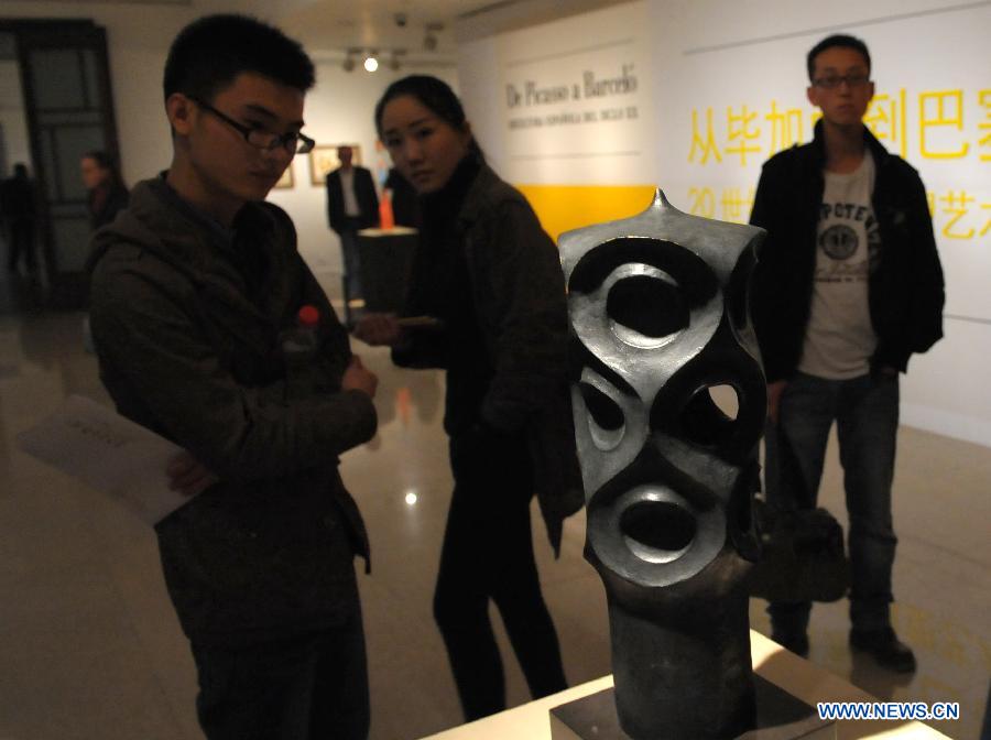 Visitors look at an artwork by Spanish architect Gaudi in an exhibition of "From Picasso to Barcelo - Spanish Sculpture of the 20th Century" in Beijing, capital of China, April 22, 2013. A total of 79 pieces of artworks of famous Spanish artists were presented in the exhibition which celebrated the 40th anniversary of the establishment of diplomatic ties between China and Spain. (Xinhua/Chen Haitong)