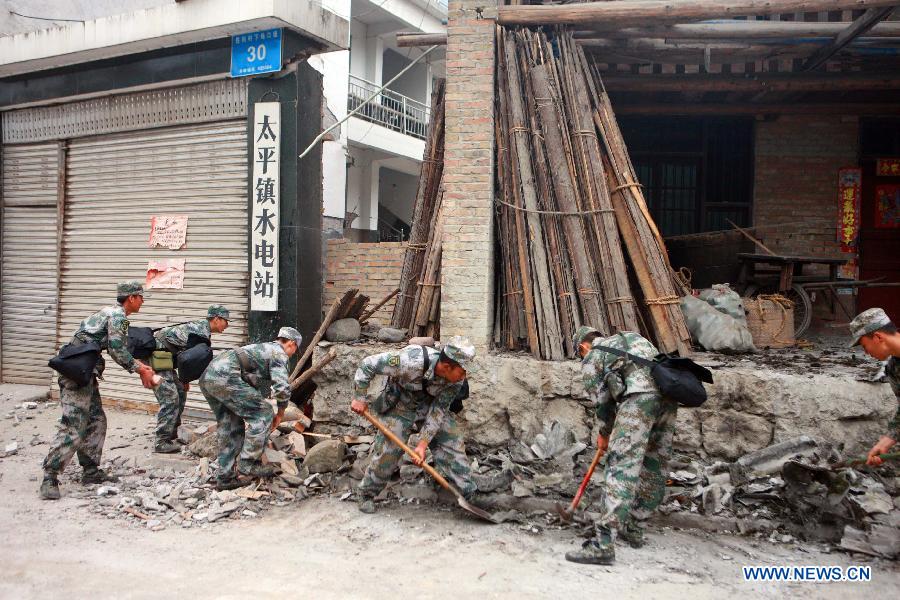 Rescuers clear the debris on a road in quake-hit Taiping Township of Lushan County, southwest China's Sichuan Province, April 21, 2013. A 7.0-magnitude quake jolted Lushan County of Ya'an City on Saturday morning. (Xinhua/Gao Xiaowen)