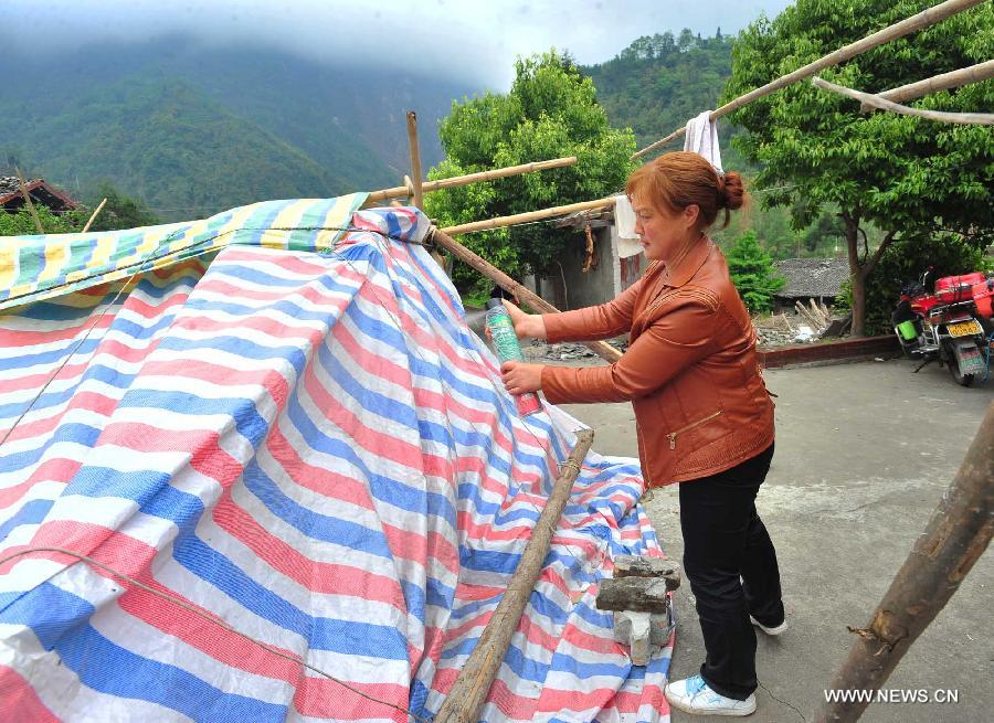 A villager sprays vermifuge to a tent in Yuxi Primary School served as an evacuation settlement in the quake-hit Yuxi Village, Baosheng Township, Lushan County in southwest China's Sichuan Province, April 22, 2013. Over 40 displaced villagers lived in makeshift tents in the settlement where they helped each other to overcome difficulties together. (Xinhua/Xiao Yijiu)