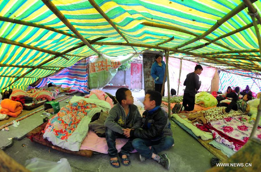 Kids amuse themselves in a tent in Yuxi Primary School served as an evacuation settlement in the quake-hit Yuxi Village, Baosheng Township, Lushan County in southwest China's Sichuan Province, April 22, 2013. Over 40 displaced villagers lived in makeshift tents in the settlement where they helped each other to overcome difficulties together. (Xinhua/Xiao Yijiu)