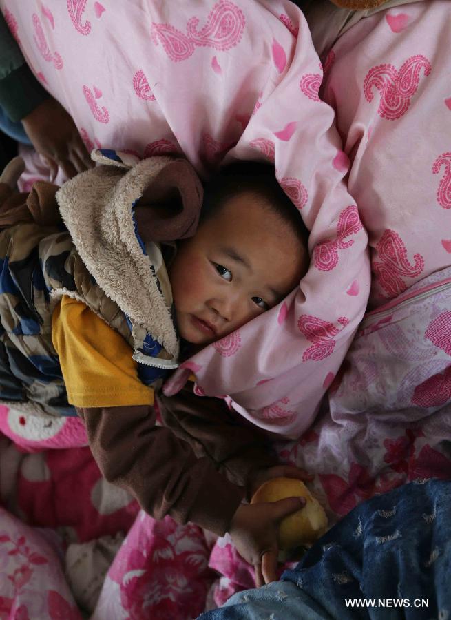 A child plays at a makeshift settlement in Lingguan Township in Baoxing County, southwest China's Sichuan Province, April 22, 2013. A 7.0-magnitude earthquake jolted Lushan County of Ya'an in the morning on April 20. Baixing is one of seriously affected areas. (Xinhua/Wang Jianmin)