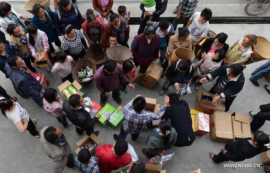 Victims get disaster relief in Hongxing Village in Longmen Township, southwest China's Sichuan Province, April 22, 2013. Quake-affected people help each other after a 7.0-magnitude earthquake jolted Lushan County of Ya'an in the morning on April 20. (Xinhua/Jiang Hongjing)
