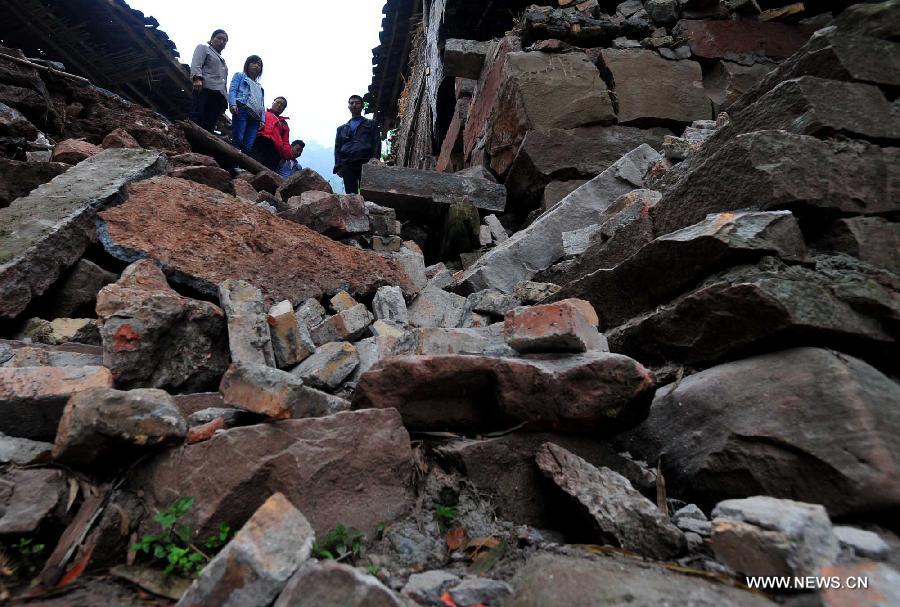 Villagers view damaged houses in the quake-hit Yuxi Village, Baosheng Township, Lushan County, southwest China's Sichuan Province, April 22, 2013. A 7.0-magnitude quake shocked Lushan on April 20, and Baosheng is one of seriously affected areas. (Xinhua/Xiao Yijiu)