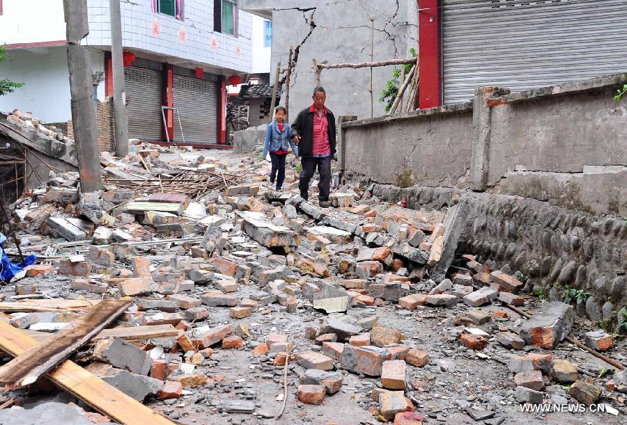 Villagers walk on ruins in the quake-hit Yuxi Village, Baosheng Township, Lushan County, southwest China's Sichuan Province, April 22, 2013. A 7.0-magnitude quake shocked Lushan on April 20, and Baosheng is one of seriously affected areas. (Xinhua/Xiao Yijiu)