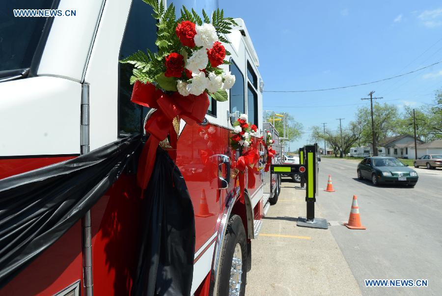 Flowers are tied on a fire vehicle to mourn for the firemen died in the fertilizer plant explosion, outside a fire station in West, Texas, the United States, April 22, 2013. (Xinhua/Wang Lei) 