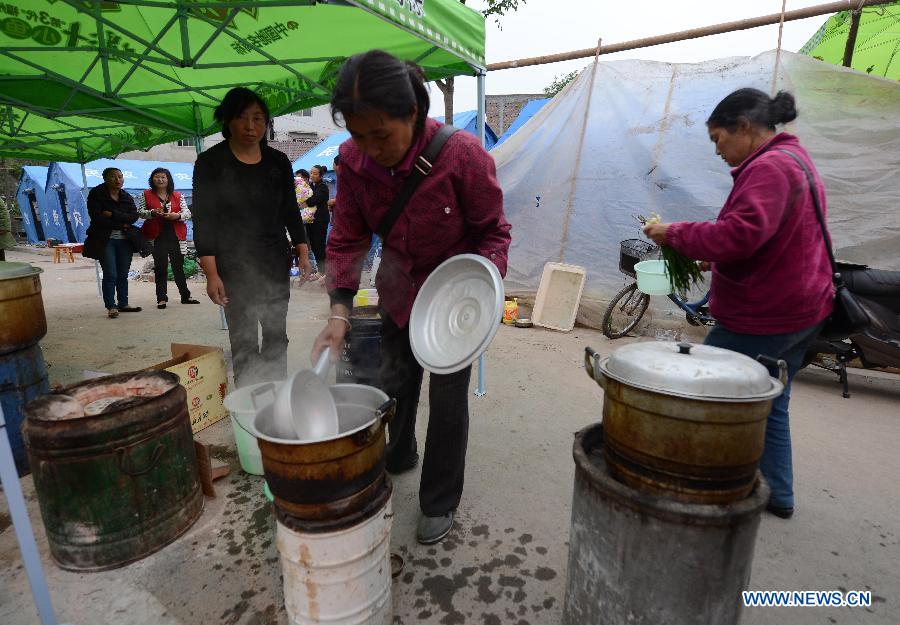 Women prepare breakfast at a temporary settlement for quake-affected people in Lushan County, southwest China's Sichuan Province, April 23, 2013. A 7.0-magnitude earthquake jolted Lushan County on April 20, leaving at least 192 people dead and 23 missing. More than 11,000 people were injured. (Xinhua/Li Gang)
