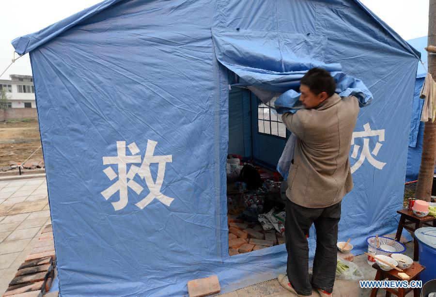A man settles a tent at a temporary settlement for quake-affected people in Lushan County, southwest China's Sichuan Province, April 23, 2013. A 7.0-magnitude earthquake jolted Lushan County on April 20, leaving at least 192 people dead and 23 missing. More than 11,000 people were injured. (Xinhua/Li Gang)