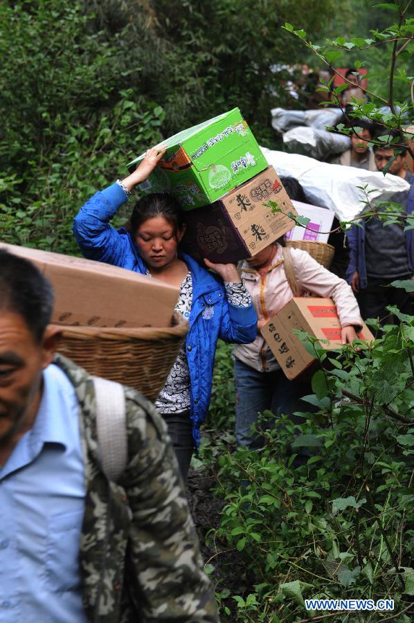 Villagers carrying disaster relief supplies walk in the mountain in quake-hit Shifeng Village of Lushan County, southwest China's Sichuan Province, April 22, 2013. The road linking the Shifeng Village with the outside had been destroyed by a 7.0-magnitude earthquake on April 20. Local villagers set up a 300-member group to climb mountains to get relief supplies outside and then return to the village. Over 40 tonnes of materials had been transported and distributed to over 2,000 villagers. (Xinhua/Li Ziheng)