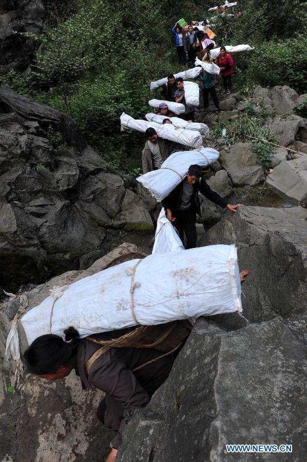 Villagers carrying disaster relief supplies walk in the mountain in quake-hit Shifeng Village of Lushan County, southwest China's Sichuan Province, April 22, 2013. The road linking the Shifeng Village with the outside had been destroyed by a 7.0-magnitude earthquake on April 20. Local villagers set up a 300-member group to climb mountains to get relief supplies outside and then return to the village. Over 40 tonnes of materials had been transported and distributed to over 2,000 villagers. (Xinhua/Li Ziheng) 
