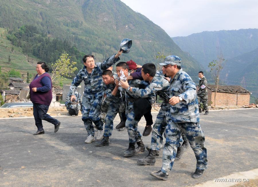 Rescuers transfer an injured old woman to take helicopter in quake-hit Lushan County, southwest China's Sichuan Province, April 22, 2013. A 7.0-magnitude earthquake jolted Lushan County on April 20, leaving at least 192 people dead and 23 missing. More than 11,000 people were injured. (Xinhua/Huang Shubo)