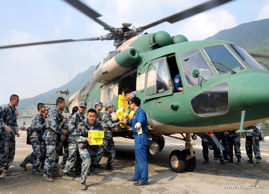 Rescuers convey food sent by a helicopter in quake-hit Lushan County, southwest China's Sichuan Province, April 22, 2013. A 7.0-magnitude earthquake jolted Lushan County on April 20, leaving at least 192 people dead and 23 missing. More than 11,000 people were injured. (Xinhua/Huang Shubo)