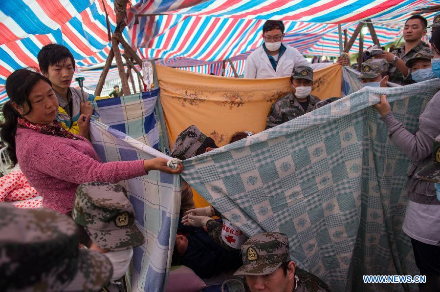 Volunteers and family members help to set up a delivery room for Yang Yan, a 20-year-old woman, in childbirth in a tent functioned as temporary hospital in quake-hit Taiping Township of Lushan County, southwest China's Sichuan Province, April 23, 2013. Yang's son was born later, and both mother and baby were fine. Yang and her husband Chen Wei arrived at the hospital in the early morning on Tuesday, after taking a long journey for over three hours from their home in Xingmin Village of the Taiping Township. This was the fourth day after a 7.0-magnitude earthquake jolted Lushan County on April 20. (Xinhua/Chen Cheng)
