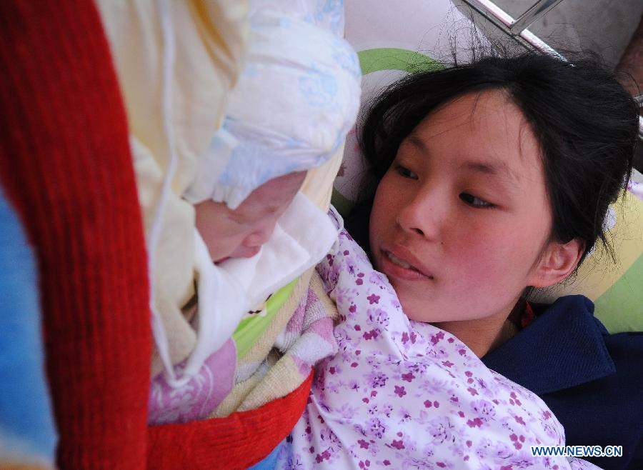 Yang Yan, a 20-year-old new mother, looks at her newborn son in a tent functioned as temporary hospital in quake-hit Taiping Township of Lushan County, southwest China's Sichuan Province, April 23, 2013. Both mother and baby were fine. Yang and her husband Chen Wei arrived at the hospital in the early morning on Tuesday, after taking a long journey for over three hours from their home in Xingmin Village of the Taiping Township. This was the fourth day after a 7.0-magnitude earthquake jolted Lushan County on April 20. (Xinhua/Chen Cheng)