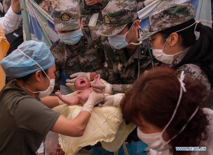 Medical workers take care of a newborn boy in a tent functioned as temporary hospital in quake-hit Taiping Township of Lushan County, southwest China's Sichuan Province, April 23, 2013. The newborn baby was named Chen Qirui, and both mother and baby were fine. The boy's mother Yang Yan, a 20-year-old woman, and father Chen Wei arrived at the hospital in the early morning on Tuesday, after taking a long journey for over three hours from their home in Xingmin Village of the Taiping Township. This was the fourth day after a 7.0-magnitude earthquake jolted Lushan County on April 20. (Xinhua/Chen Cheng)