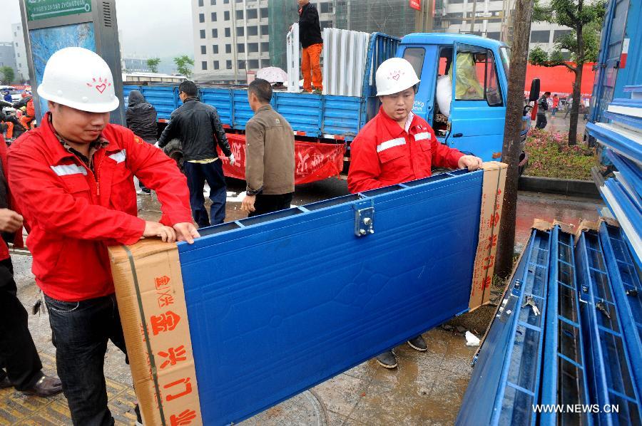 Workers unload building materials to prepare the construction of temporary housing in quake-hit Lushan County, southwest China's Sichuan Province, April 23, 2013. A 7.0-magnitude earthquake jolted Lushan County on April 20. (Xinhua/Li Ziheng)