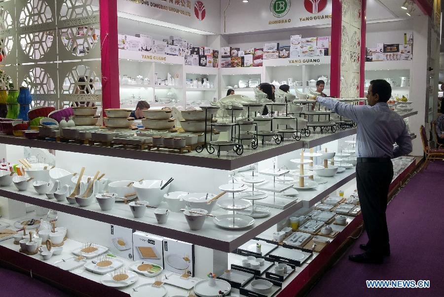 A buyer chooses ceramic products during the second phase of the 113th Canton Fair, or China Import and Export Fair, in Guangzhou, capital of south China's Guangdong Province, April 23, 2013. The phase 2 of the fair will last five days from April 23 to 27, presenting consumer goods, home decorations and gifts. (Xinhua/Lu Hanxin)