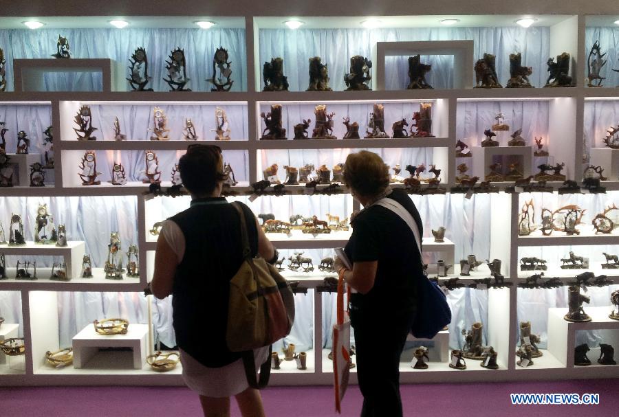 Visitors look at handicrafts during the second phase of the 113th Canton Fair, or China Import and Export Fair, in Guangzhou, capital of south China's Guangdong Province, April 23, 2013. The phase 2 of the fair will last five days from April 23 to 27, presenting consumer goods, home decorations and gifts. (Xinhua/Lu Hanxin)