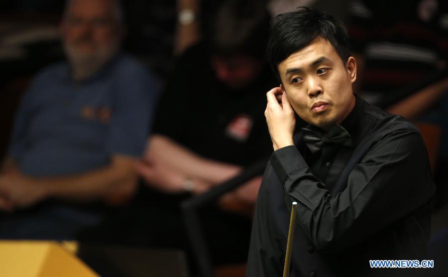 Marco Fu from Hong Kong, China, reacts during his first round match against Matthew Stevens (not shown in picture) of Wales in the World Snooker Championship at the Crucible Theatre in Sheffield, Britain, April 23, 2013. (Xinhua/Wang Lili)
