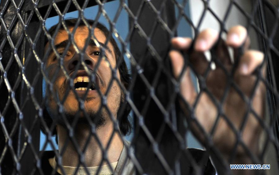 An al-Qaeda militant stand behind bars for his final hearing at a state security court in Sanaa, Yemen, on April 23, 2013. According to the official Saba News Agency, the Yemeni security court sentenced ten Yemenis to jail terms ranging from four to 6 years after convicting them of belonging to al-Qaeda in the Arabian Peninsula and forming armed terror gangs to carry out attacks against Yemeni and foreign interests. (Xinhua/Mohammed Mohammed)