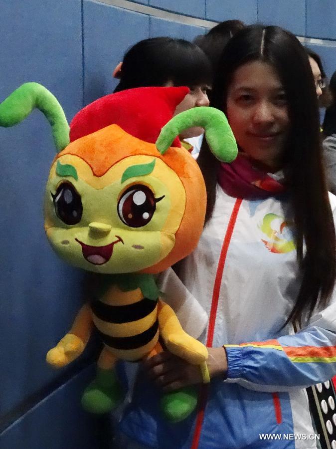 A volunteer presents the mascot designed for the volunteers of the ninth China (Beijing) International Garden Expo at a press conference in Beijing, capital of China, April 23, 2013. The mascot for volunteers is given a nickname of "Little V Bee" as V stands for victory and bee is a symbol of diligence in Chinese culture. A total of 51,096 people have so far registered for the volunteer service during the expo. (Xinhua/Li Xin)