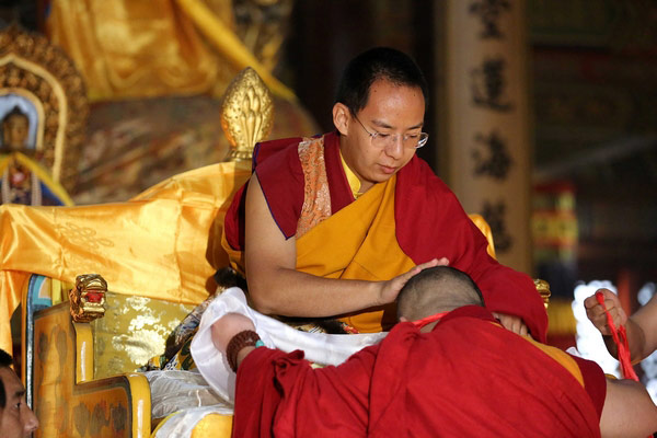 The 11th Panchen Lama touches a monk's head to give blessings in Yonghegong Lama Temple in Beijing, April 23, 2013. [Photo/China Tibet Online]