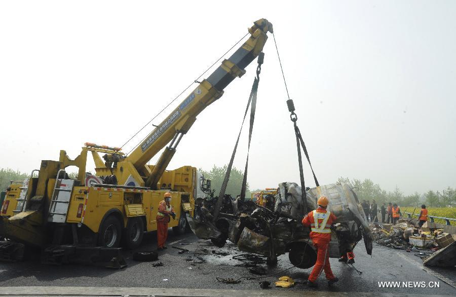 Rescuers work at the accident site after a passenger vehicle rear-ended a truck at an expressway in Yancheng City, east China's Jiangsu Province, April 24, 2013. A fire broke out after the rear-end collision occurred, killing all the 8 people in the passenger vehicle.(Xinhua/Zhou Chenyang) 